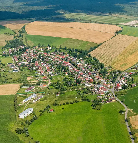 Letecký pohľad na Rakúsy v lete, obec obklopená poliami